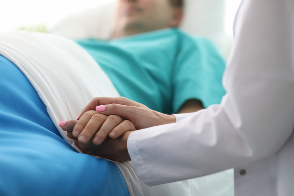 doctor holding the hand of a patient in bed