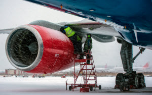 Two mechanics working on a Northwest Airlines jet engine