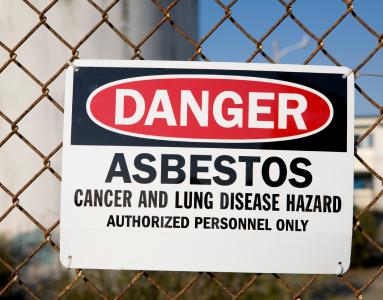 asbestos exposure warning sign on a chainlink fence