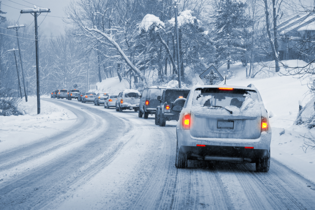 line of cars driving on snowy road