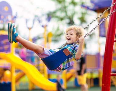 child playing on the swings in a park