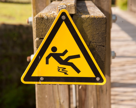 slip and fall signage on a wooden surface