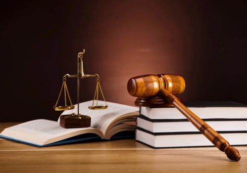 a gavel and justice scale placed on top of a book