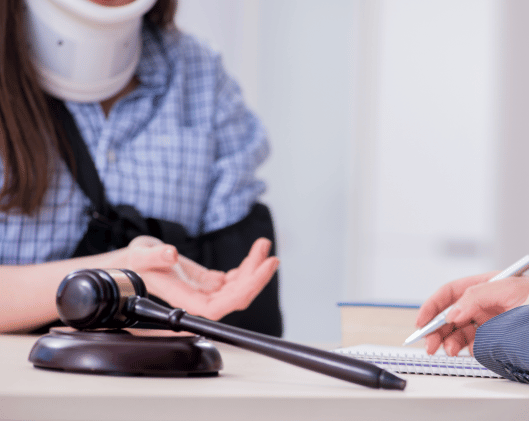 injured person in sling and neck brace talking to lawyer