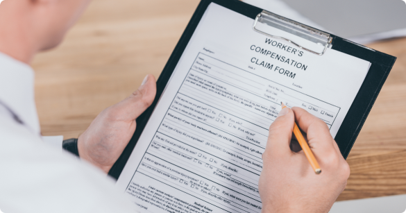 Individual filling out a workers' compensation claim form for Hastings Personal Injury Lawyers at a desk