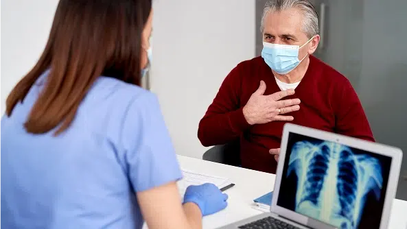 Female doctor analyzing the mesothelioma patient's lung X-rays during visit